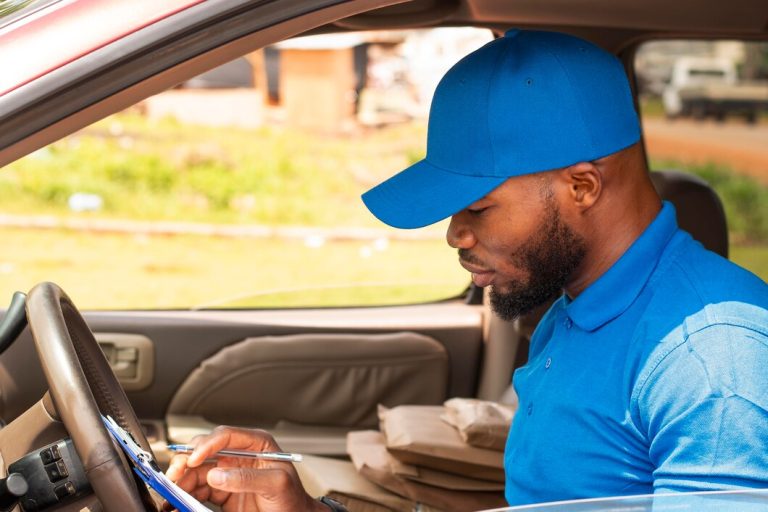 Gros plan sur le livreur avec des documents en voiture